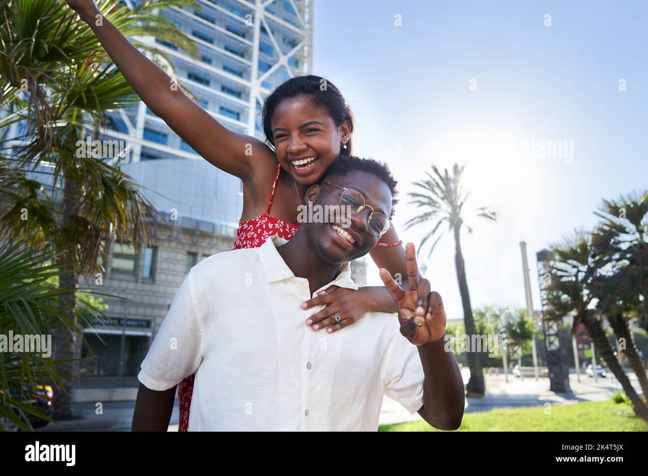 Portrait joyeux d'un jeune couple de race mixte en vacances sur une île. Homme africain donnant le pigeyback. Banque D'Images