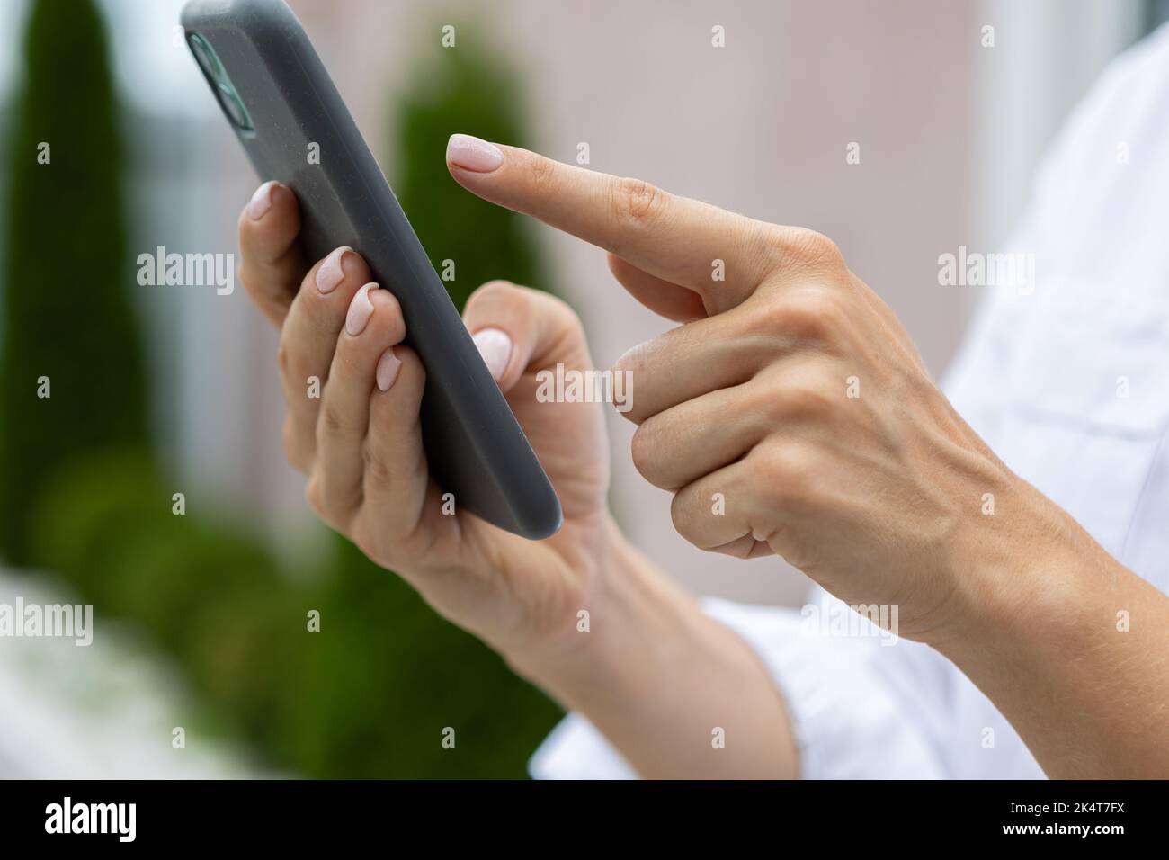 les femmes tiennent un téléphone mobile moderne dans la rue. nouvelles, éducation, application moderne, commande, travail en ligne Banque D'Images