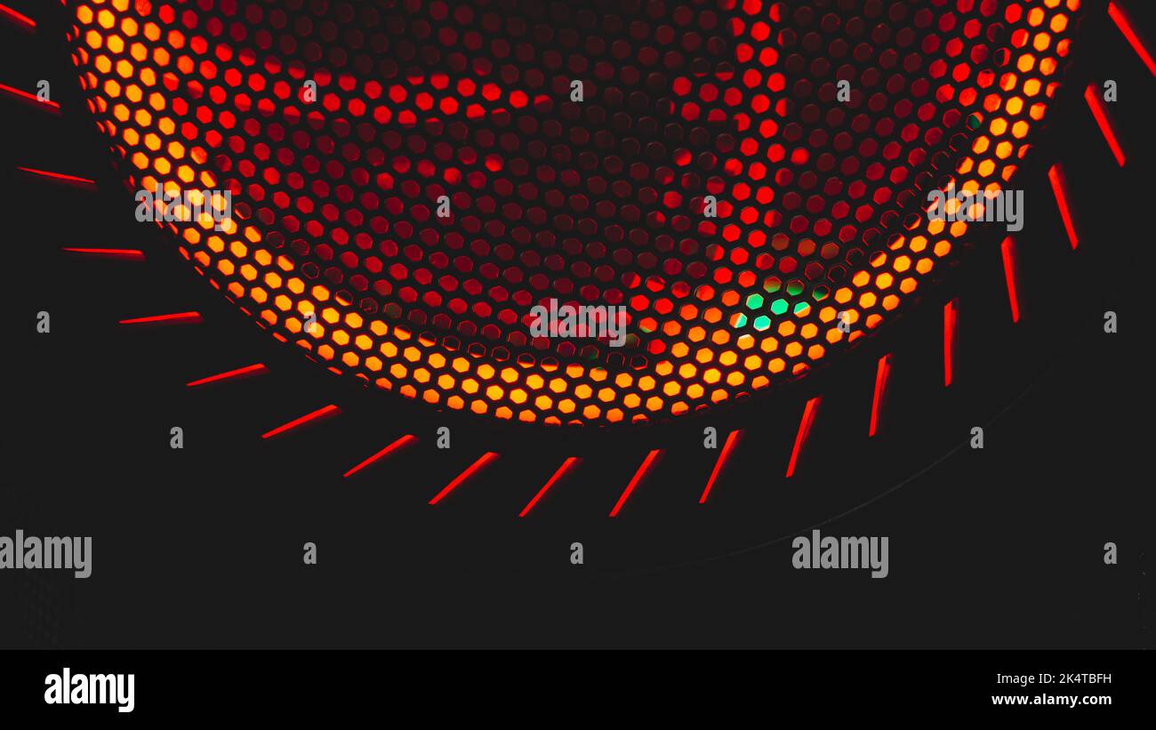 Détail du ventilateur de l'ordinateur avec arrière-plan abstrait de lumière rouge. Gros plan de grille plus froide. Éclairage led rvb Banque D'Images