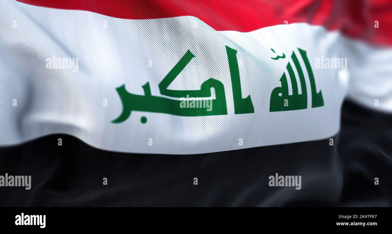 Vue rapprochée du drapeau national de l'Irak qui agite dans le vent. La République d'Iraq est un État d'Asie occidentale. Arrière-plan texturé en tissu. Mise au point sélective Banque D'Images
