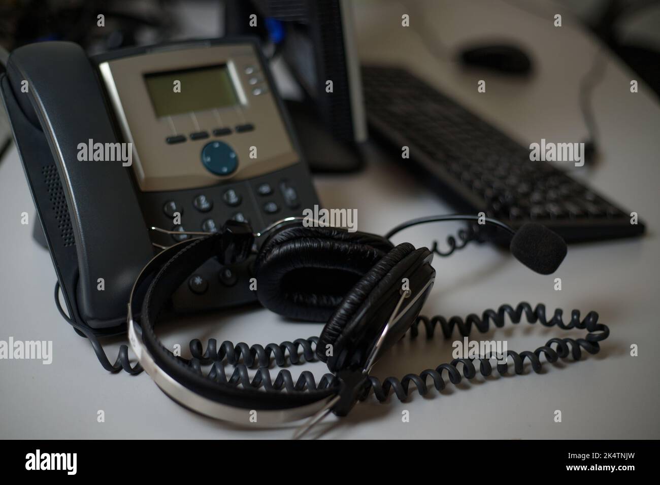 Téléphone fixe et casque sur le bureau à l'intérieur, à proximité. Assistance à la communication, centre d'appels et service d'assistance à la clientèle. Banque D'Images