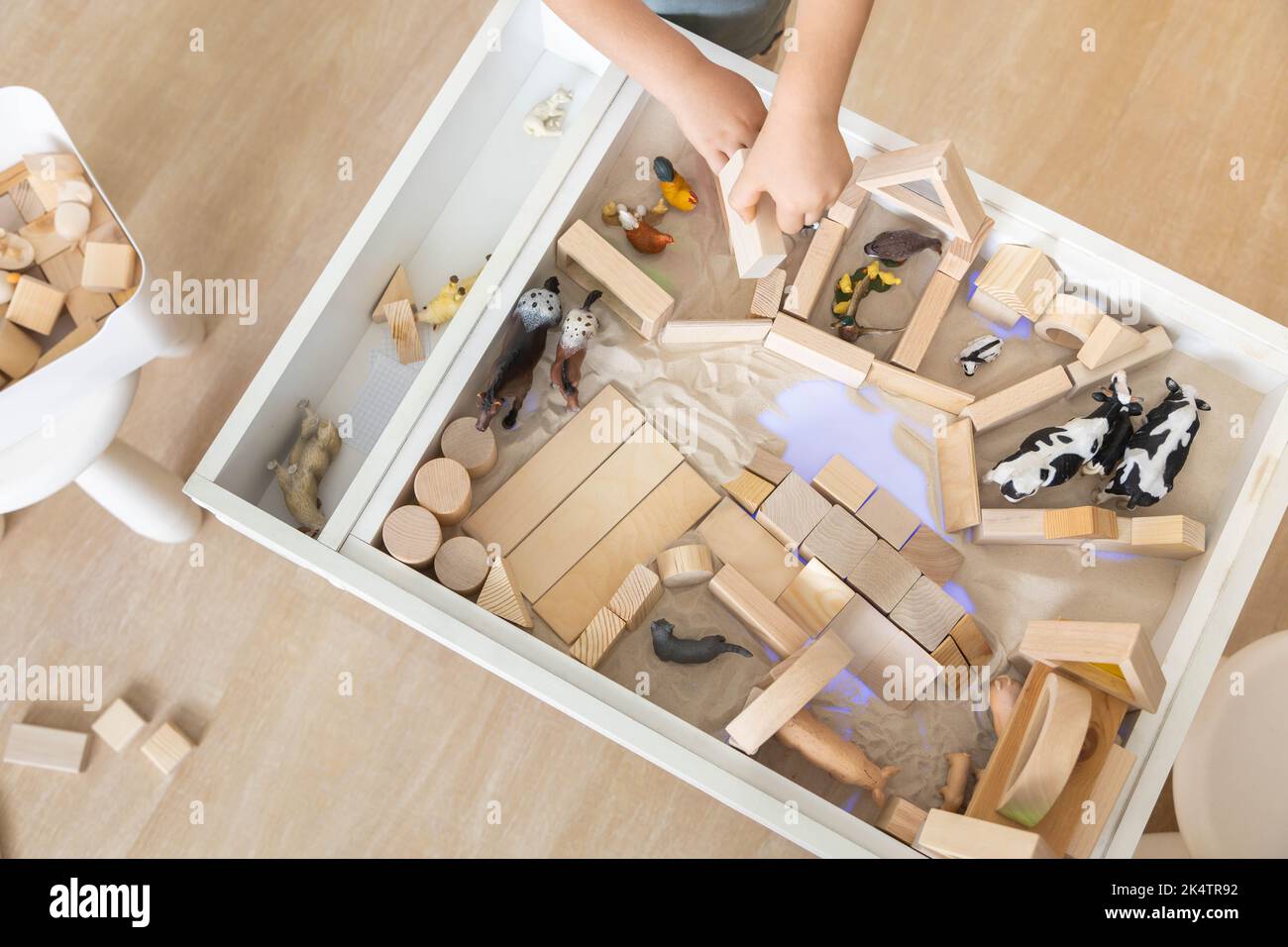Mignon garçon enfant jouant sensoriel boîte cinétique table de sable ...