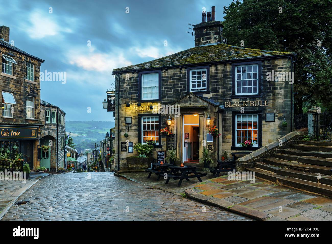 Haworth main Street (colline escarpée, vieux bâtiments, lumière du soir de l'heure bleue, village historique des sœurs Bronte, pub de classe 2) - West Yorkshire, Angleterre, Royaume-Uni. Banque D'Images