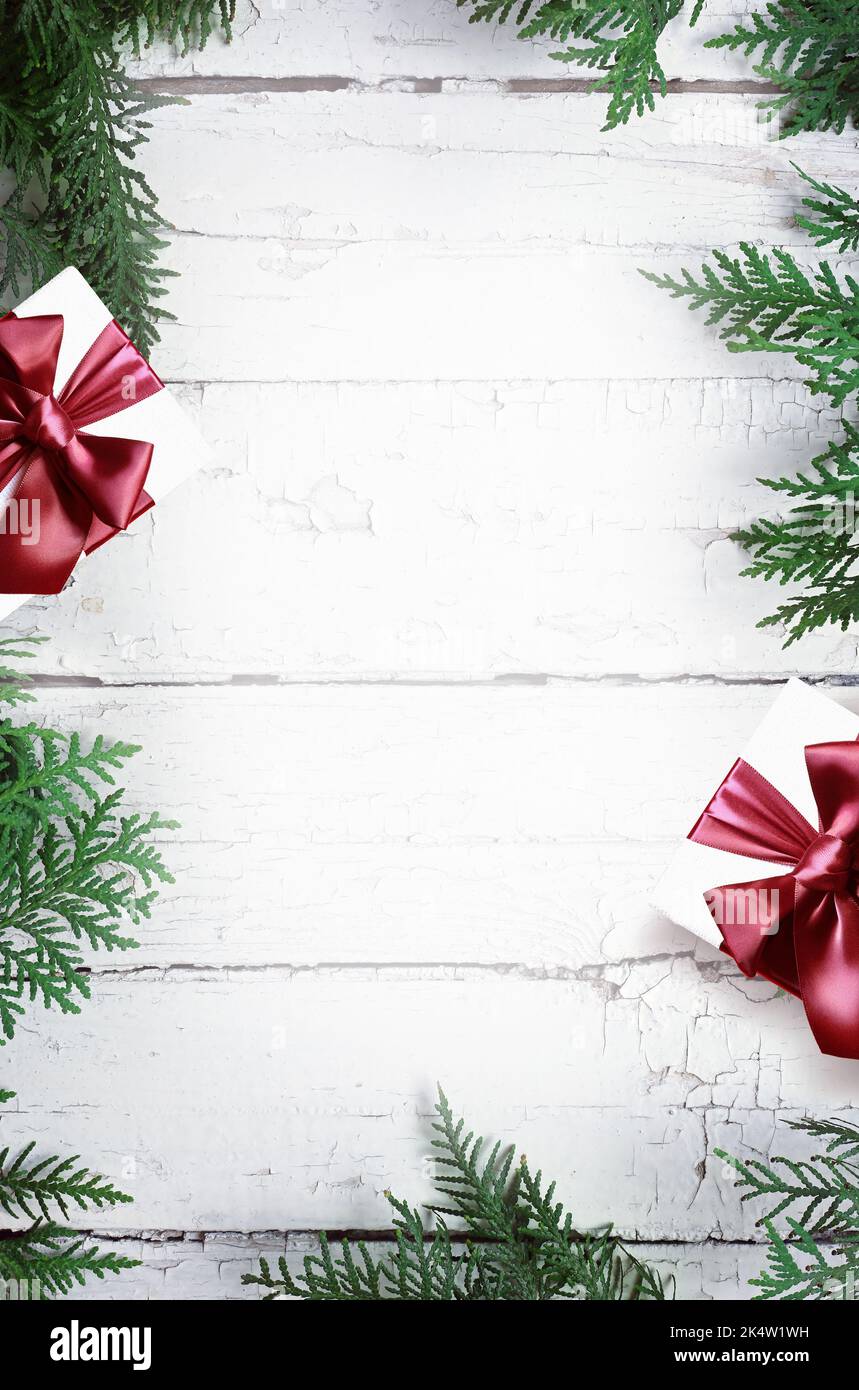 Composition de Noël. Cadeau de Noël, pin, branches de sapin sur fond blanc en bois. Flat lay, vue de dessus, espace de copie. Banque D'Images