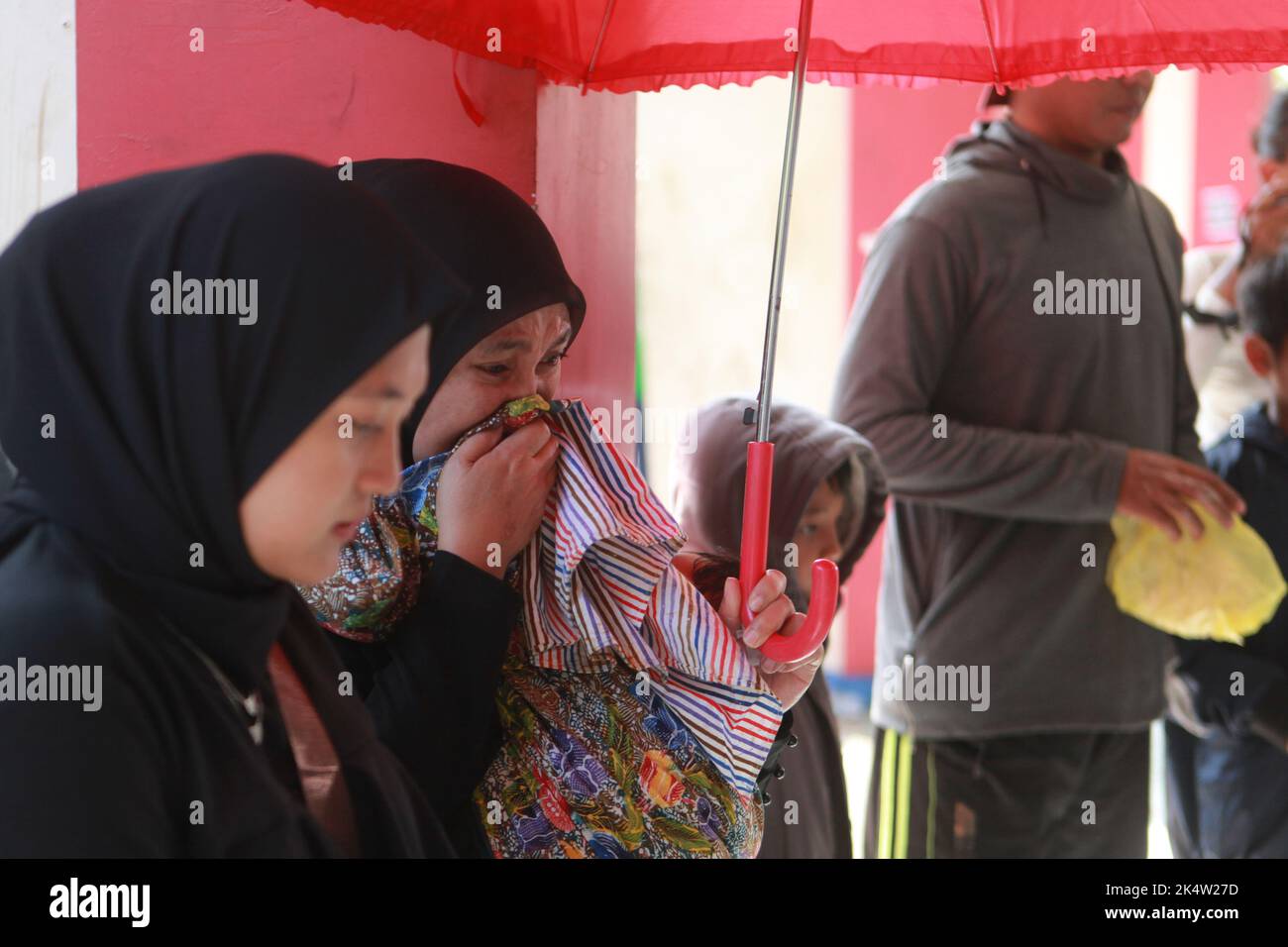 Malang, Indonésie. 4th octobre 2022. Les gens pleurent les victimes devant l'entrée du stade Kanjuruhan à Malang, East Java, Indonésie, le 4 octobre 2022. Le gouvernement indonésien a mis sur pied une équipe indépendante d'enquête pour découvrir la cause du Stampede, qui a tué 125 personnes et blessé au moins 320 autres personnes. Le Stampede s'est produit samedi fin au stade Kanjuruhan à Malang regency après que le club AREMA Malang a perdu à Persebaya Surabaya lors d'un match de football de la ligue indonésienne. Credit: Bayu Novanta/Xinhua/Alamy Live News Banque D'Images