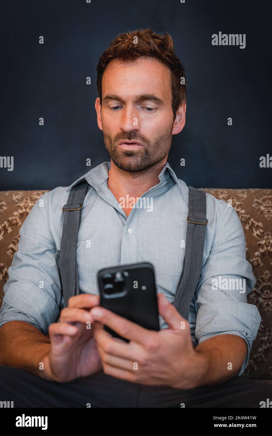 L'homme tape sur son téléphone portable Banque D'Images