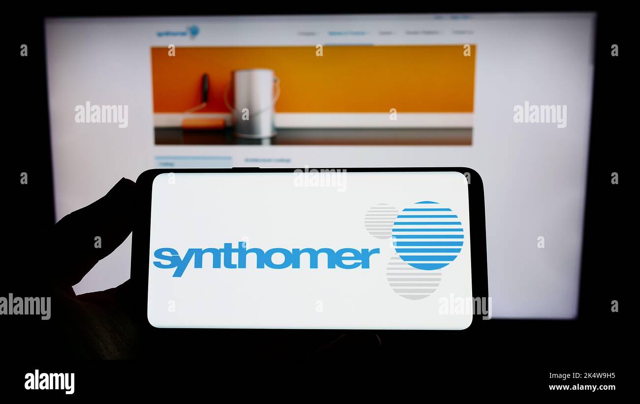 Personne tenant un smartphone avec le logo de la société britannique Synthomer plc sur écran devant le site Web. Mise au point sur l'affichage du téléphone. Banque D'Images