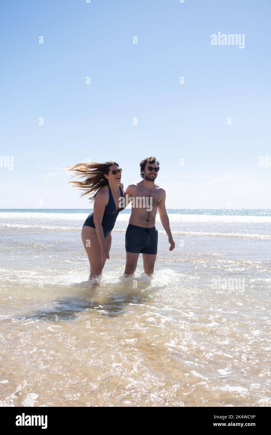 Heureux couple debout dans la mer en été, France Banque D'Images