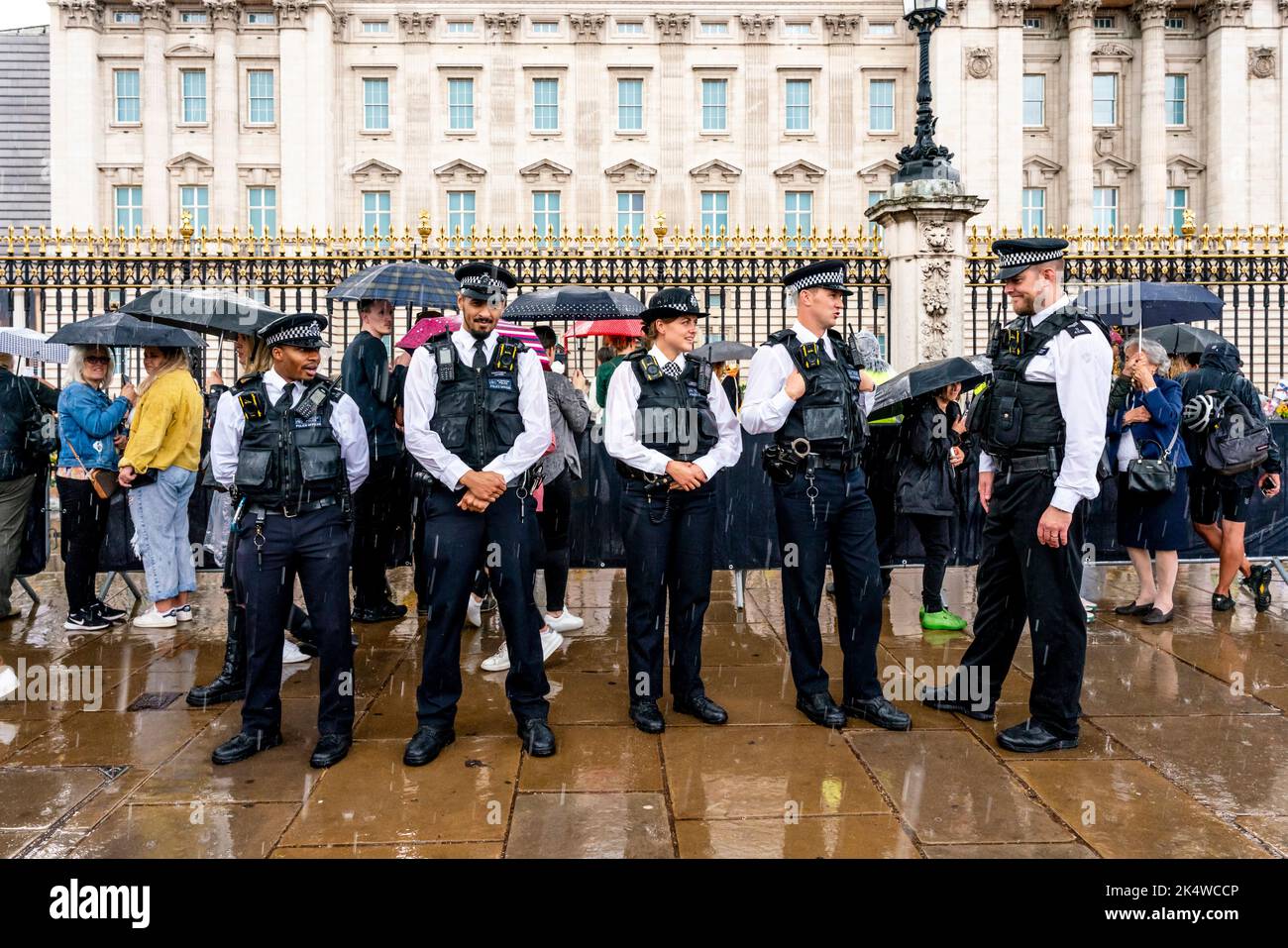 Des officiers de police métropolitains se trouvent à l'extérieur de Buckingham Palace, dans la ville de Rain, à Londres, au Royaume-Uni. Banque D'Images