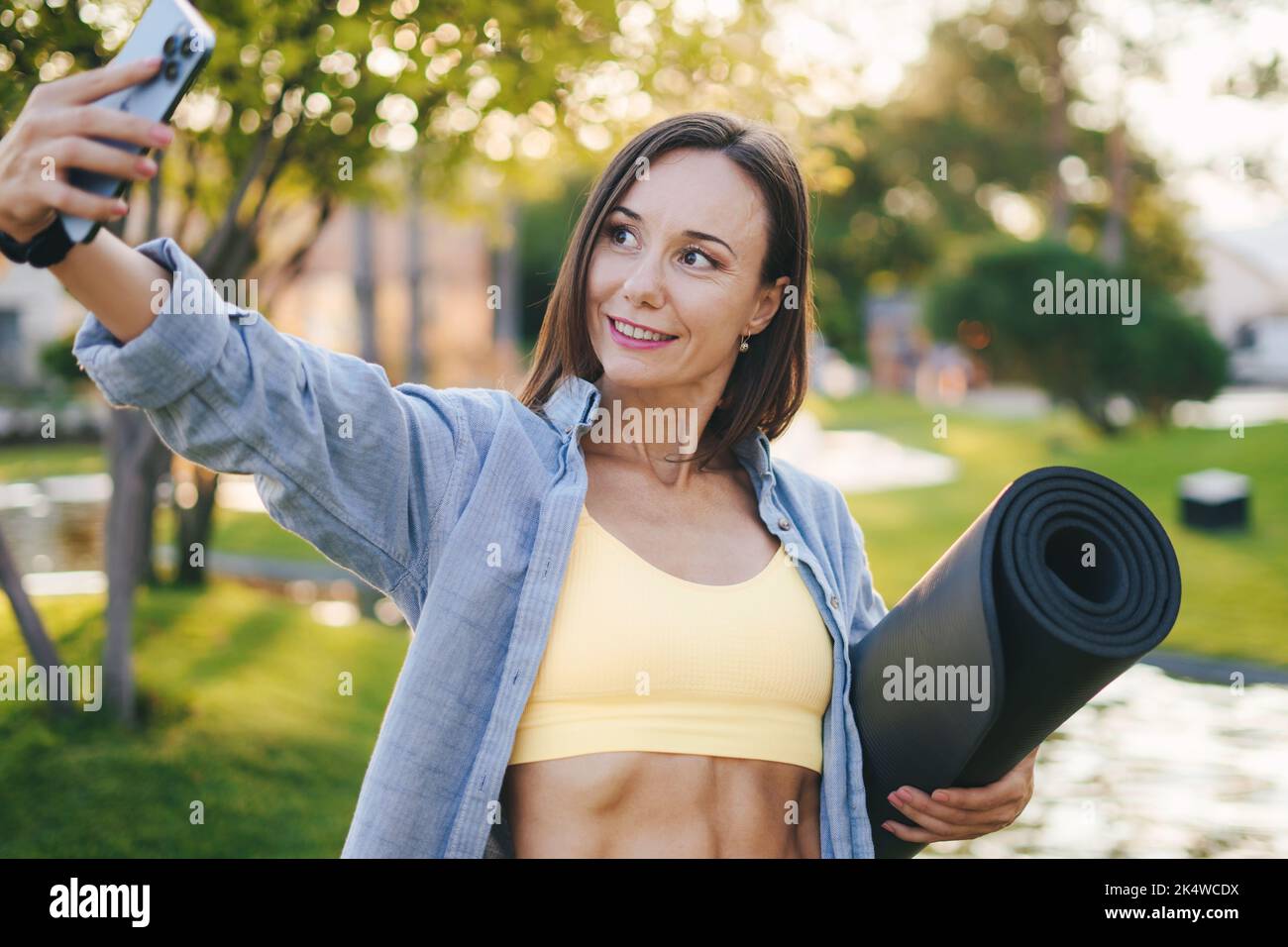 Prise de vue d'une belle femme sportive prenant un selfie par son téléphone mobile après avoir fait du jogging à l'extérieur. Les gens sont en forme de corps sain. Entraînement physique. Un mode de vie sain Banque D'Images