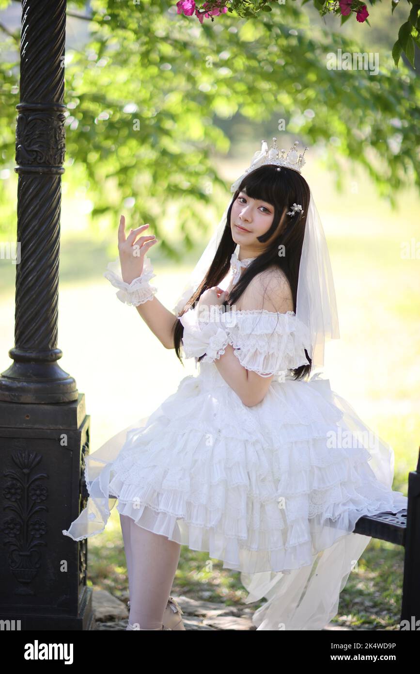 Belle jeune femme avec robe lolita blanche avec jardin européen de la mode  japonaise Photo Stock - Alamy