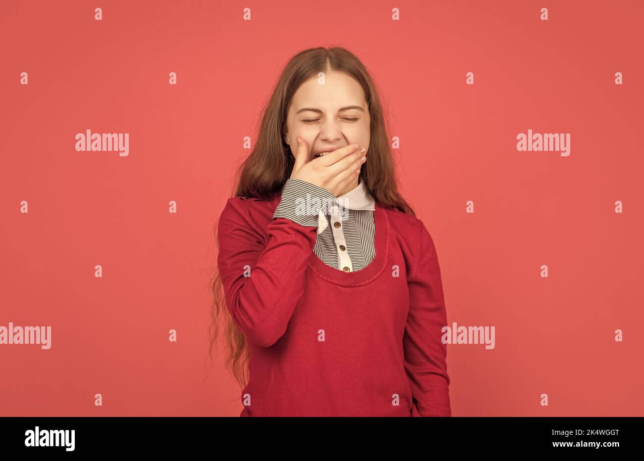 fille de l'adolescence à l'aube endormi dans l'uniforme scolaire sur fond rouge, l'enfance Banque D'Images