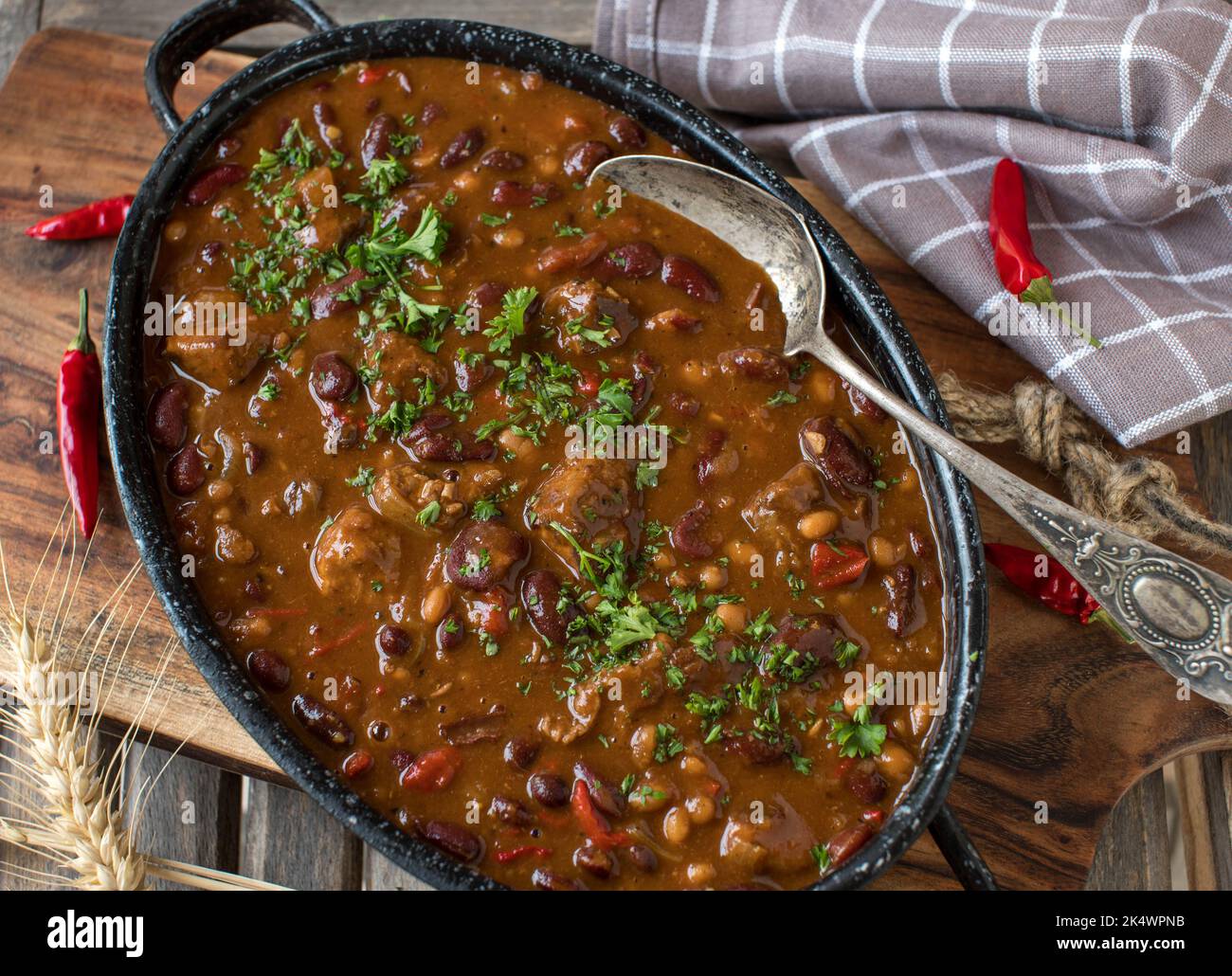Chili con carne avec cubes de viande dans une casserole rustique sur table en bois Banque D'Images