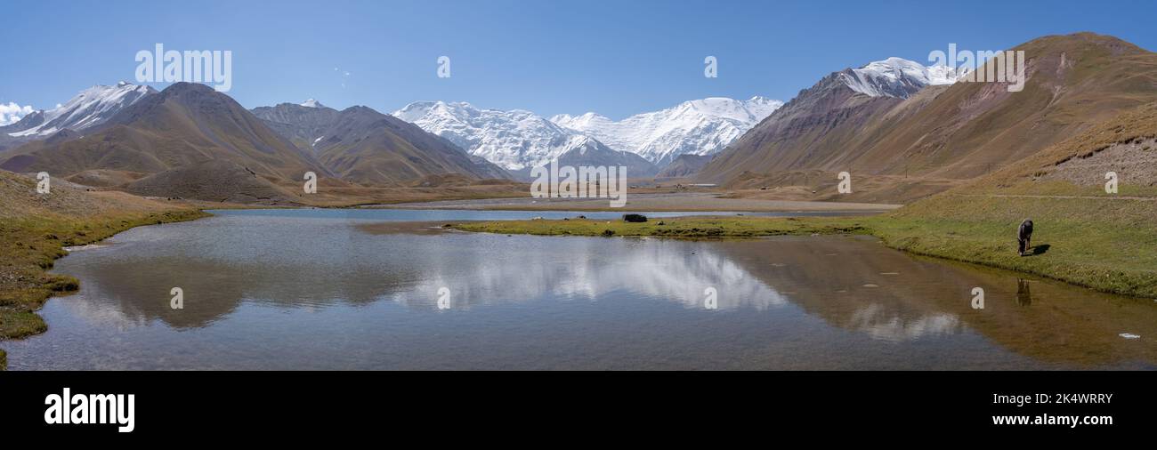 Vue panoramique de Achik Tash basecamp de Lénine pic Aka Ibn Sina dans la chaîne de montagnes Trans-Alay, sud du Kirghizistan avec lac et réflexion Banque D'Images