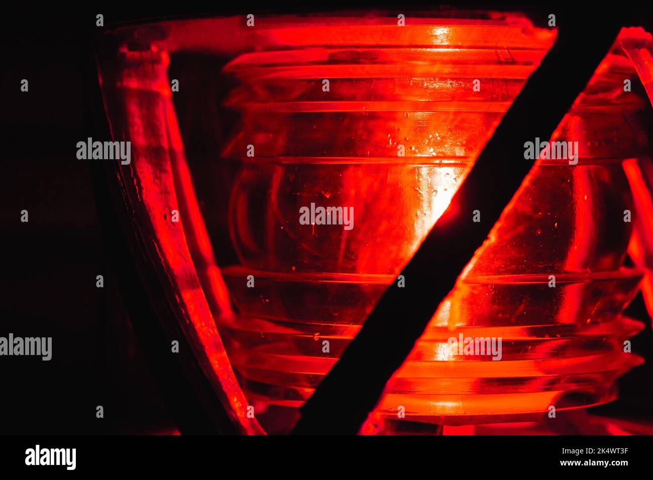 La lampe rouge brille dans un cadre métallique sur le dessus d'un phare, photo de gros plan avec une mise au point douce sélective Banque D'Images
