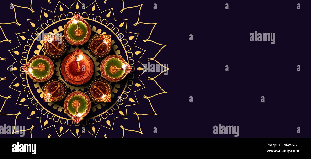 Deepavali Diwali, festival hindou des lumières. Lampe à huile Diya allumée sur fond noir traditionnel, vue du dessus. Banque D'Images