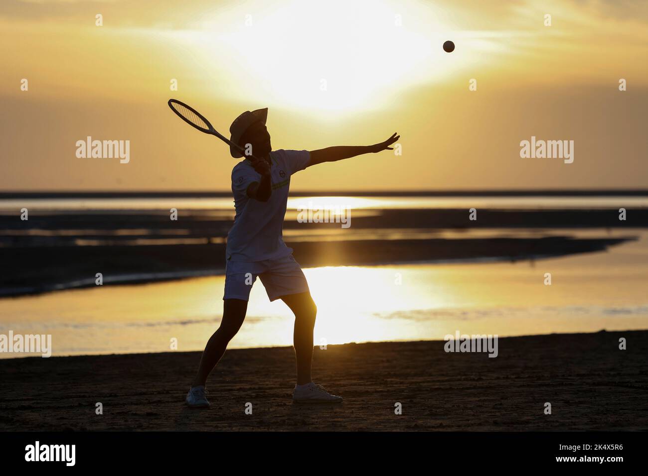 Silhouette d'un joueur de tennis rétro sur la plage au soleil du soir sur l'île de Borkum, Allemagne. Banque D'Images