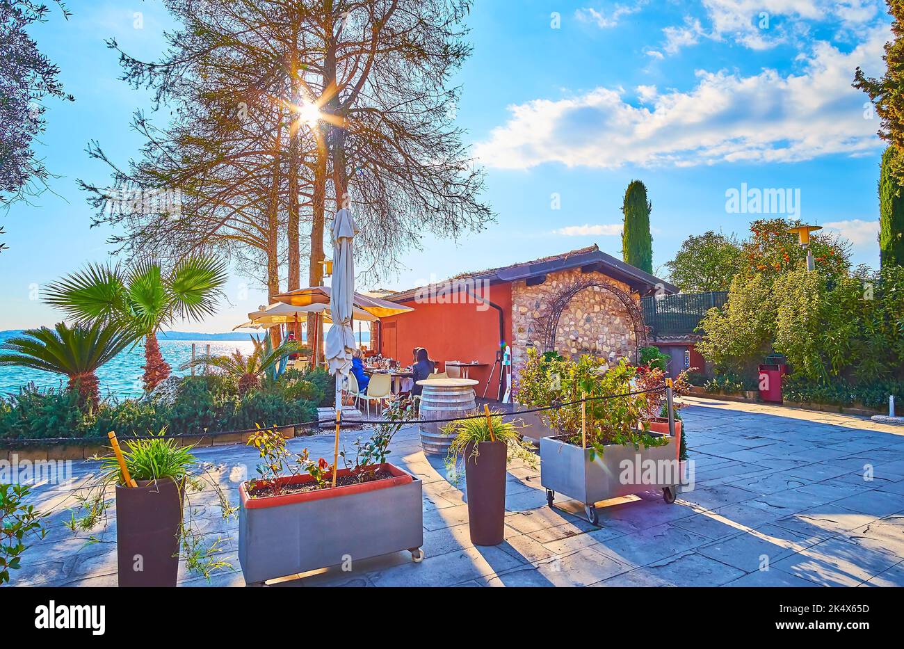 Le petit café confortable, entouré de plantes verdoyantes sur la rive du lac de Garde, Sirmione, Italie Banque D'Images