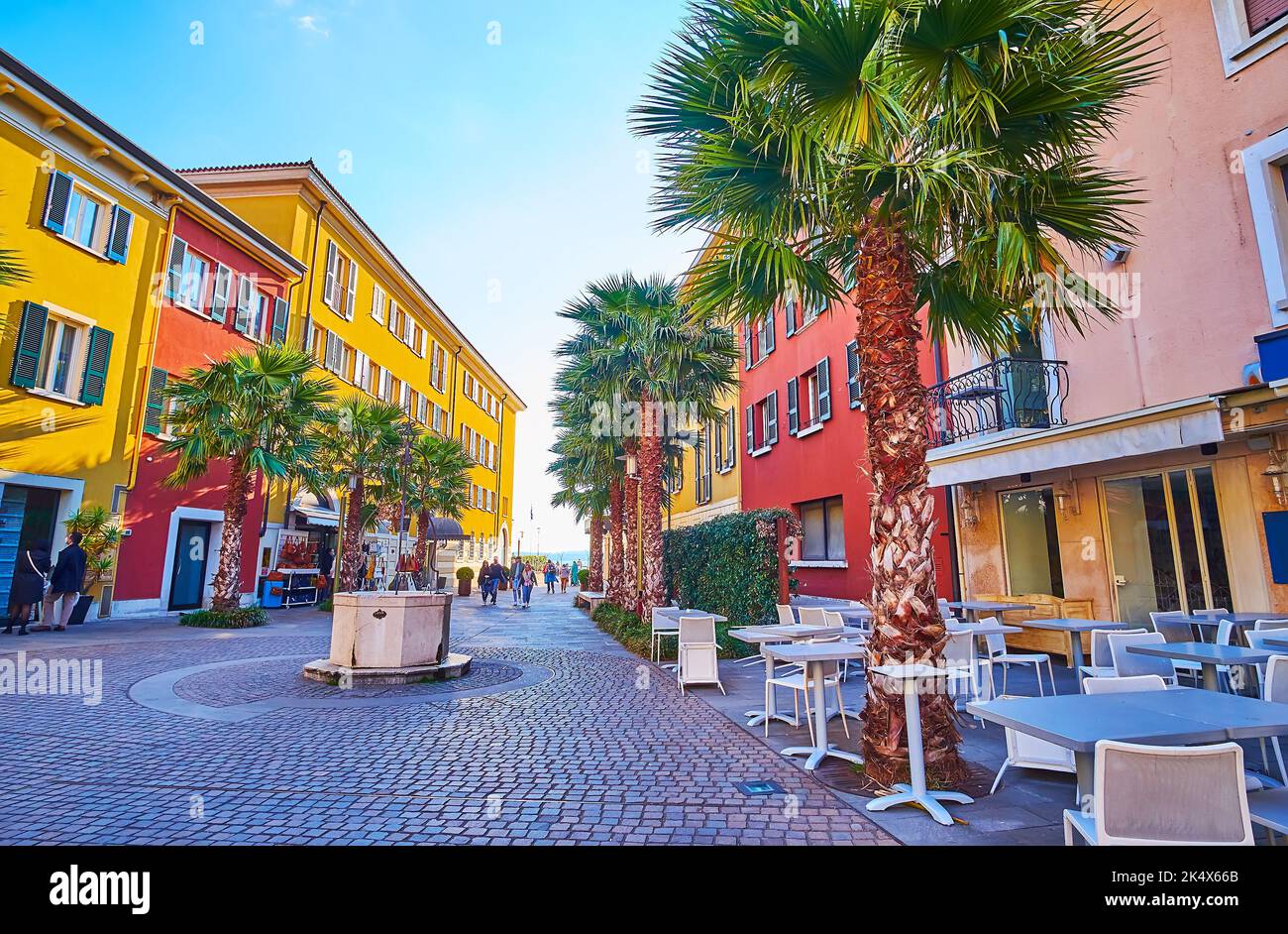 L'Antico Pozzo antique bien sur la place Piazza Castello, bordée de terrasses de cafés extérieurs, Sirmione, Italie Banque D'Images