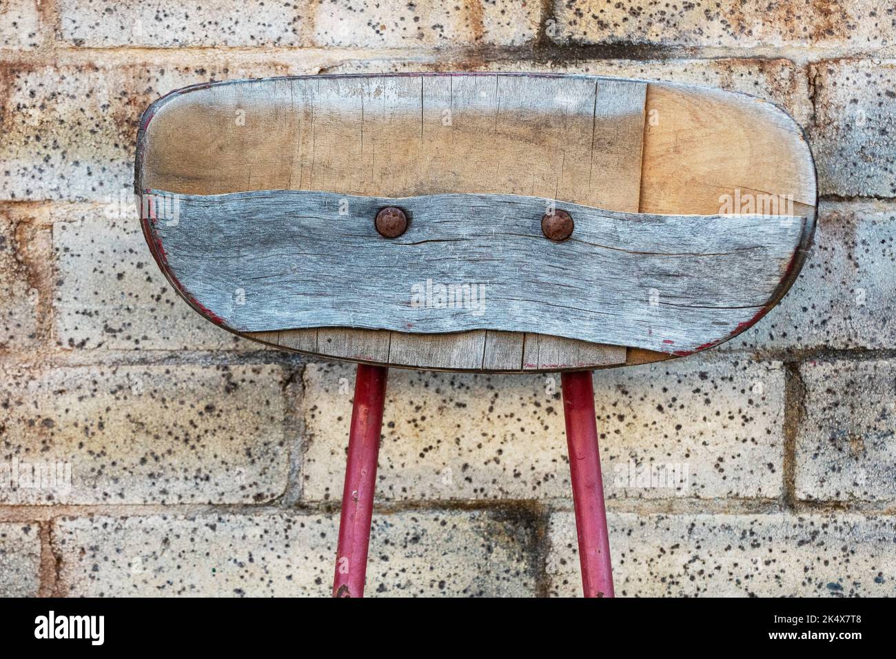 L'arrière de l'ancienne chaise en contreplaqué en milieu urbain ressemble à un visage Banque D'Images