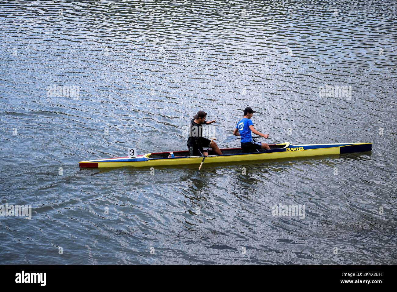 Deux jeunes athlètes font du canoë sur la rivière, contrôlant les oars. Entraînement sportif actif en plein air. Copier l'espace. Chisinau, Moldova - juillet 2022 Banque D'Images