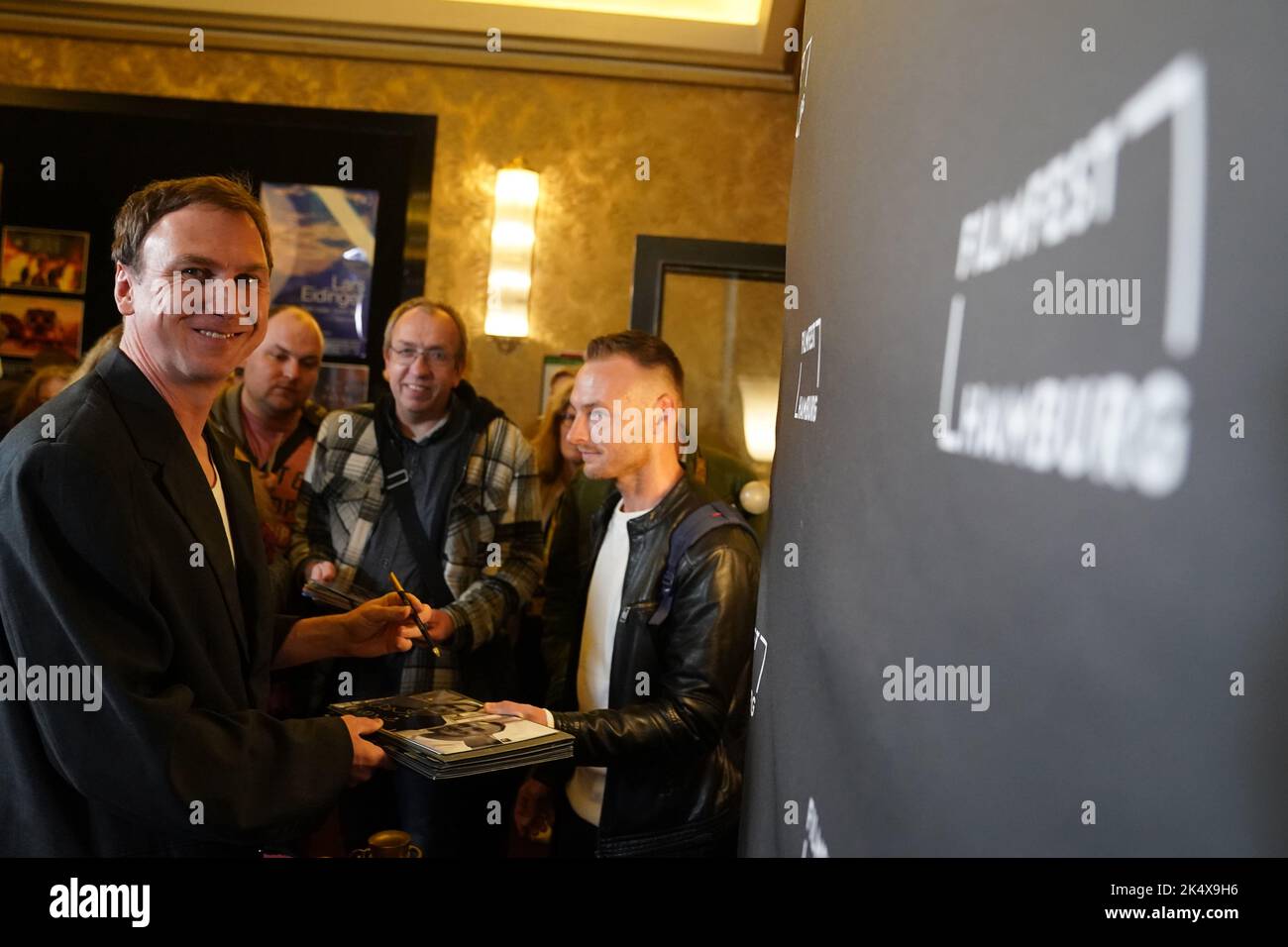 Hambourg, Allemagne. 04th octobre 2022. L'acteur Lars Eidinger signe des autographes pour les fans en attente après le photocall du film 'Lars Eidinger - être ou ne pas être' au Filmfest 30th Hambourg dans le passage Kino. Credit: Marcus Brandt/dpa/Alay Live News Banque D'Images
