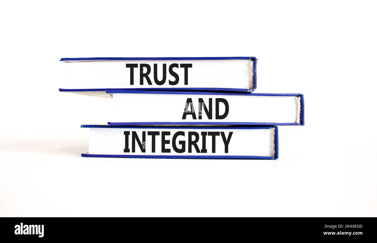 Symbole de confiance et d'intégrité. Mots de concept confiance et intégrité sur les livres. Magnifique table blanche fond blanc. Affaires, psychologique et de confiance et Banque D'Images