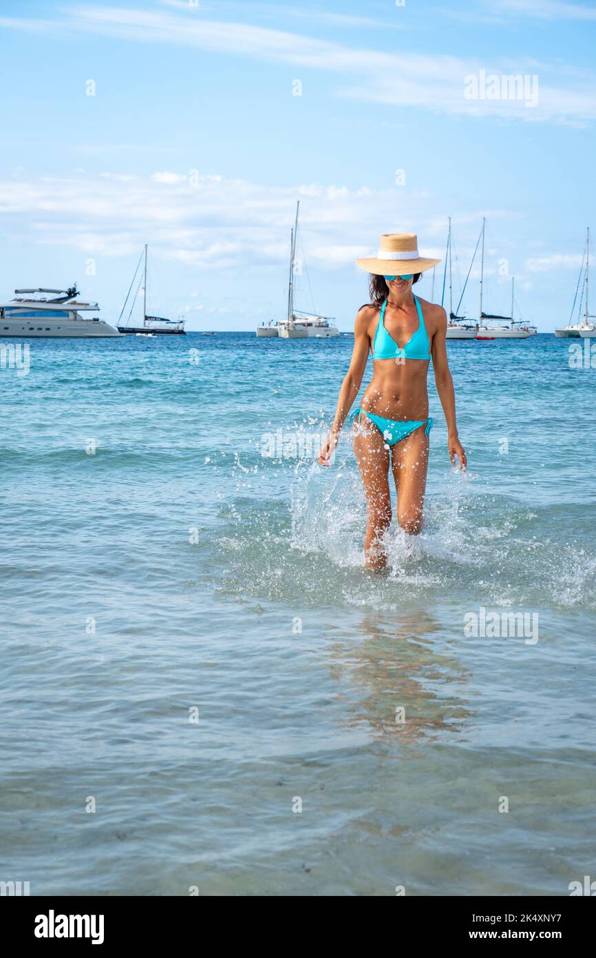 Femme avec bikini turquoise et chapeau posé sur une plage à Ibiza Banque D'Images