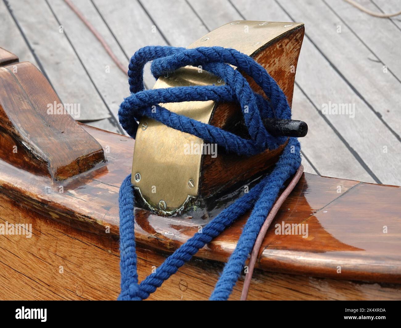 Bollard d'amarrage sur le pont d'un navire en bois avec une corde bleue. Banque D'Images