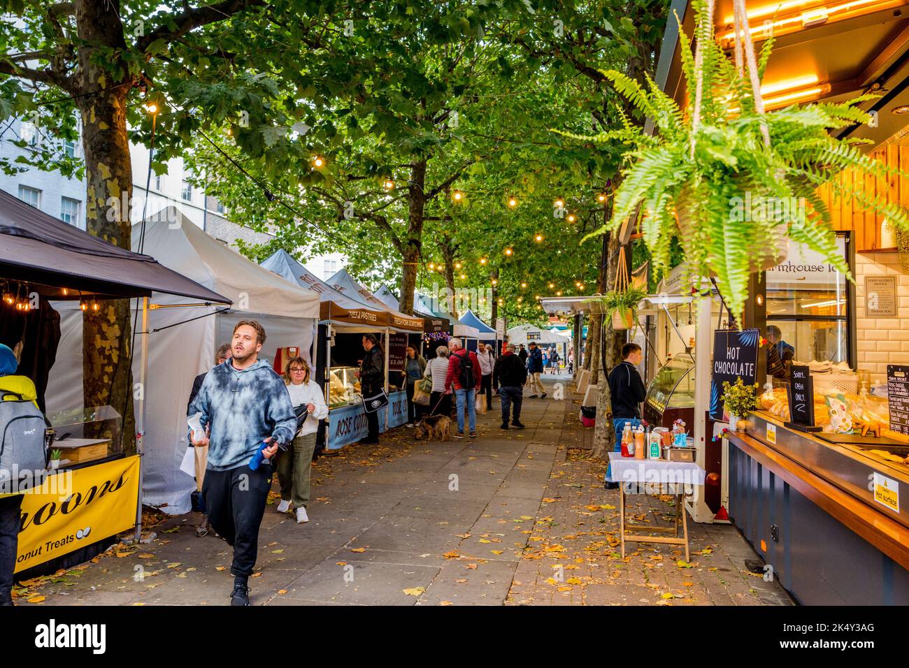 Les amateurs de shopping et de marche à travers le marché alimentaire en plein air le long des lignes d'arbres de Parliament Street dans la ville aciente de York, Yorkshire. Banque D'Images