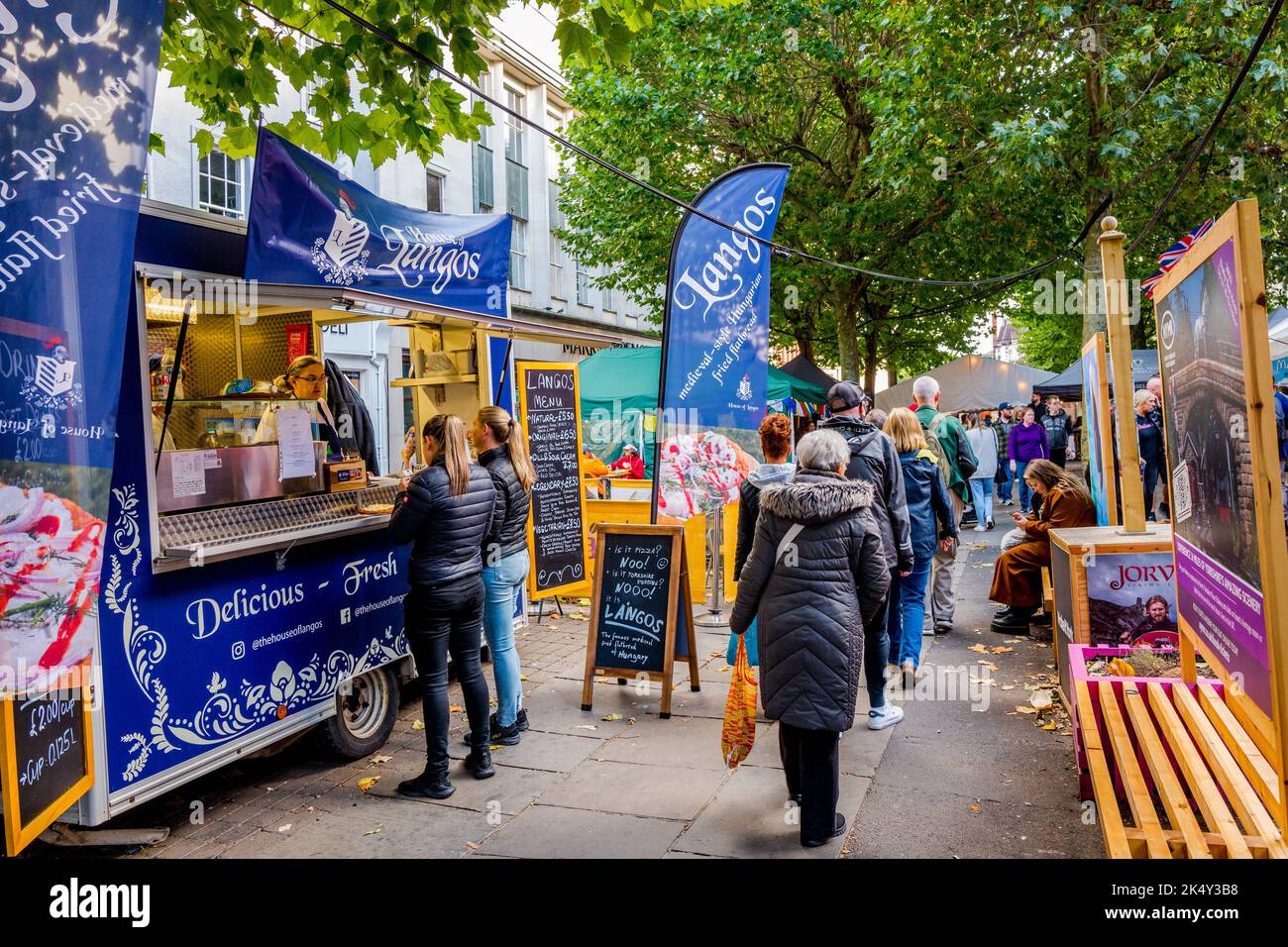 Les amateurs de shopping et de marche à travers le marché alimentaire en plein air le long des lignes d'arbres de Parliament Street dans la ville aciente de York, Yorkshire. Banque D'Images