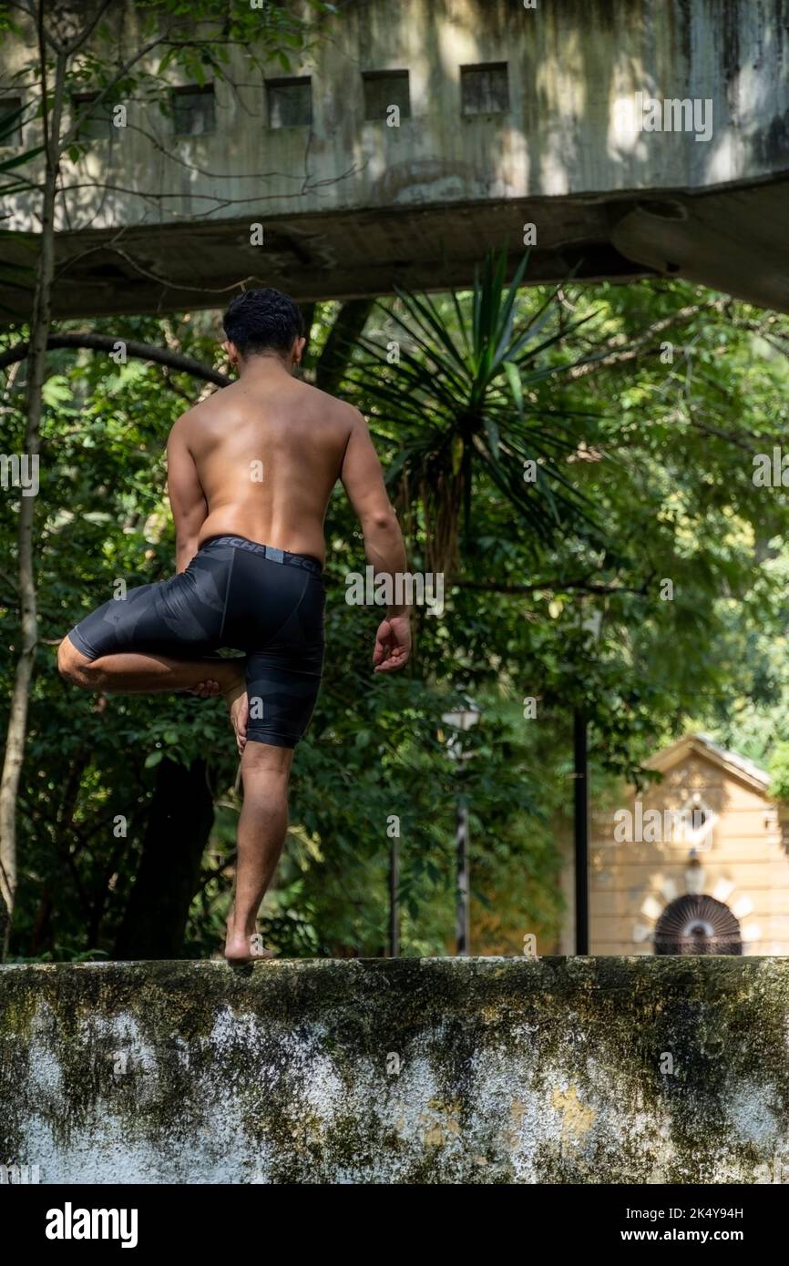 Latino-américain faisant la posture du yoga, la posture du yoga, Bee en arrière Prsthatah Brahmara, forêt Banque D'Images