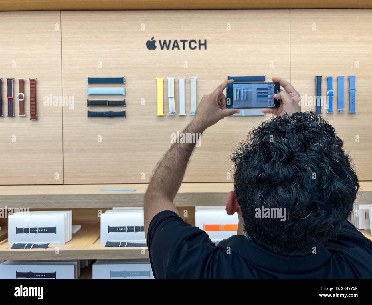 Vue arrière d'un Indien prenez une photo du bracelet Apple Watch qui est affiché sur le mur à l'intérieur de l'Apple Store Banque D'Images