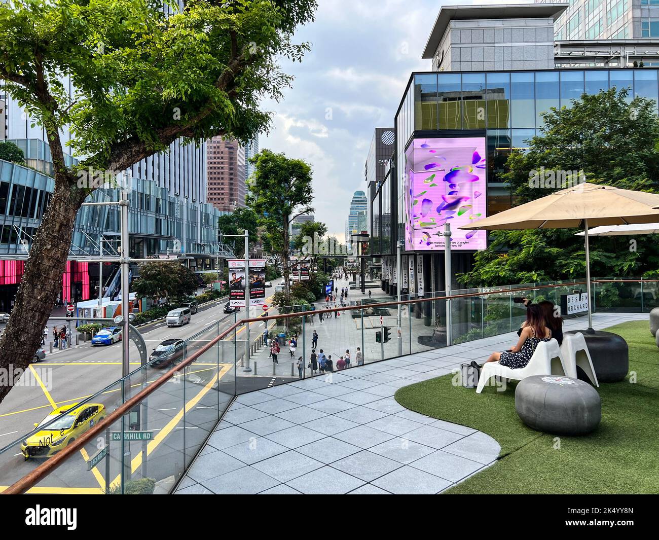 Deux dames assises sur des bancs au niveau 2, surplombant la zone commerçante d'Orchard Road, district 9, Singapour. Banque D'Images