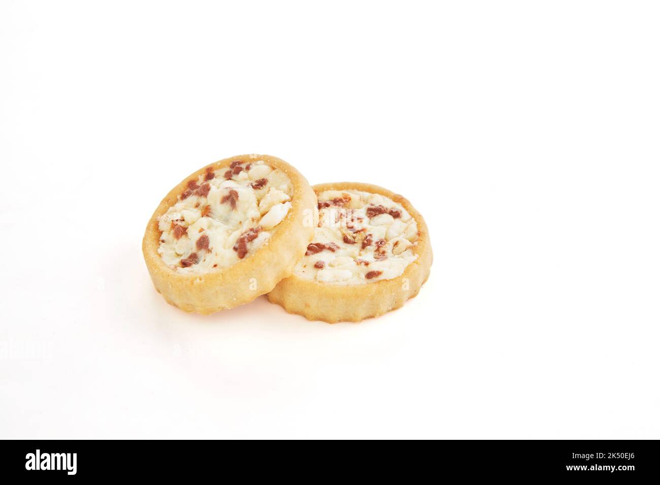 Biscuits au chocolat et garniture de crème, grains germés et morceaux de chocolat sur fond blanc Banque D'Images