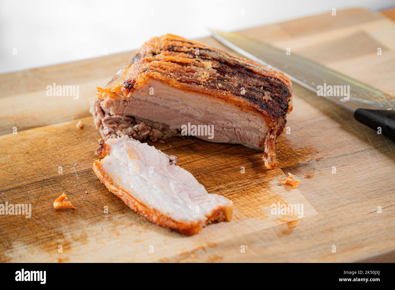 Rôti de porc danois (rôti de côtes) « Ribbensteg » sur une planche de bois Banque D'Images