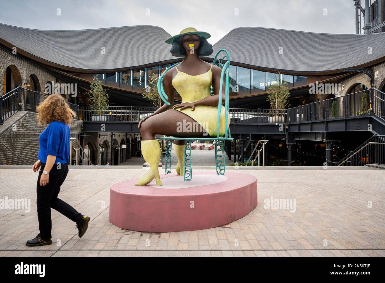 Londres, Royaume-Uni. 5 octobre 2022. Une femme passe devant Tschabalala Self's 'SEED', un ouvrage public récemment dévoilé commandé par avant Arte, à Coal Drops Yard près de King's Cross. Le bronze à grande échelle mesure près de 3 mètres et est la première sculpture publique de l’artiste. Credit: Stephen Chung / Alamy Live News Banque D'Images