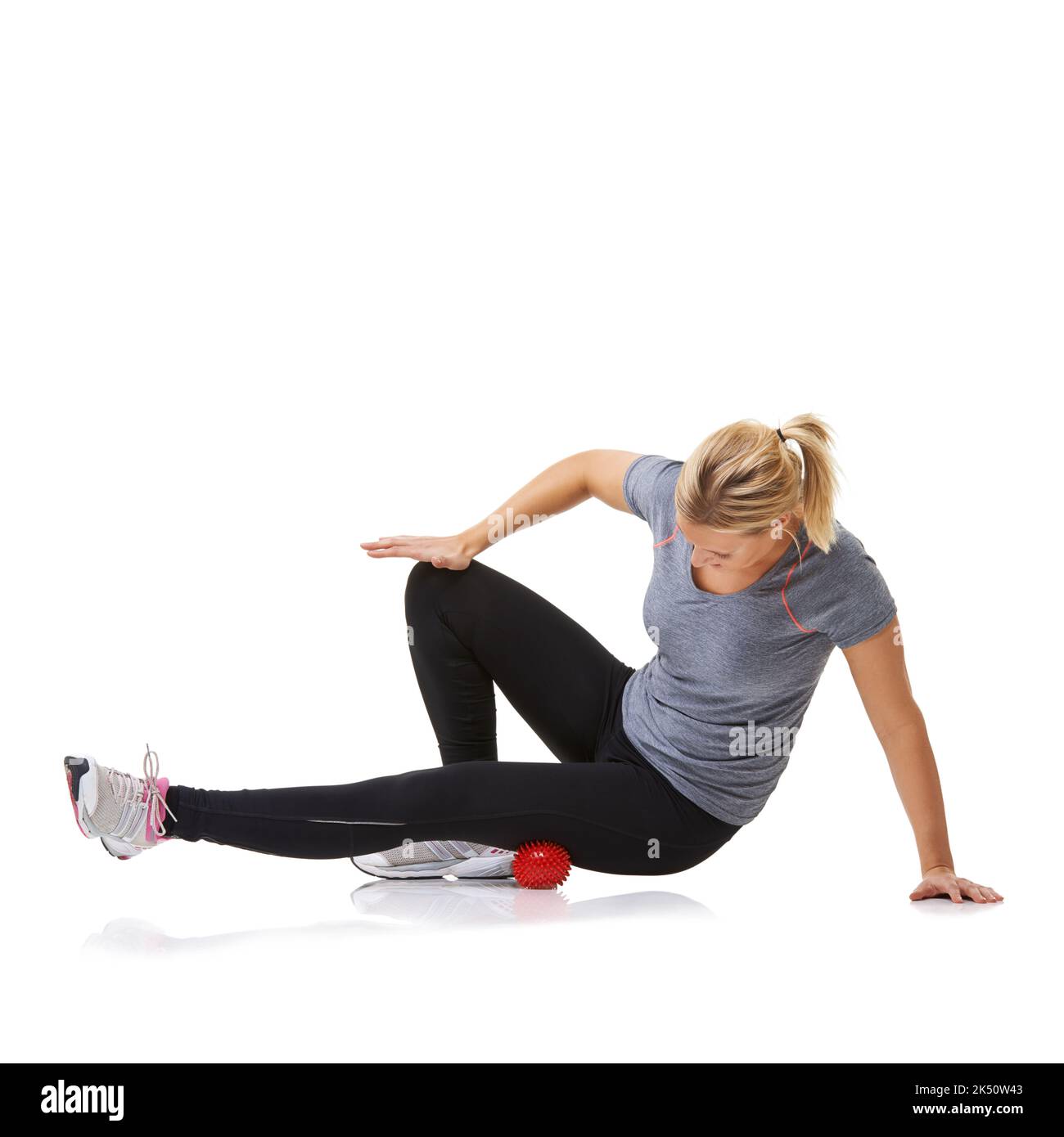 Déploiement de ses cuisses. Une jeune femme s'entraîner à l'aide d'une balle d'exercice. Banque D'Images