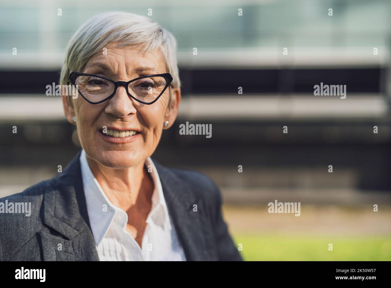 Portrait en plein air de la femme d'affaires sénior. Le bon interlocuteur est souriant et regarde l'appareil photo. Banque D'Images