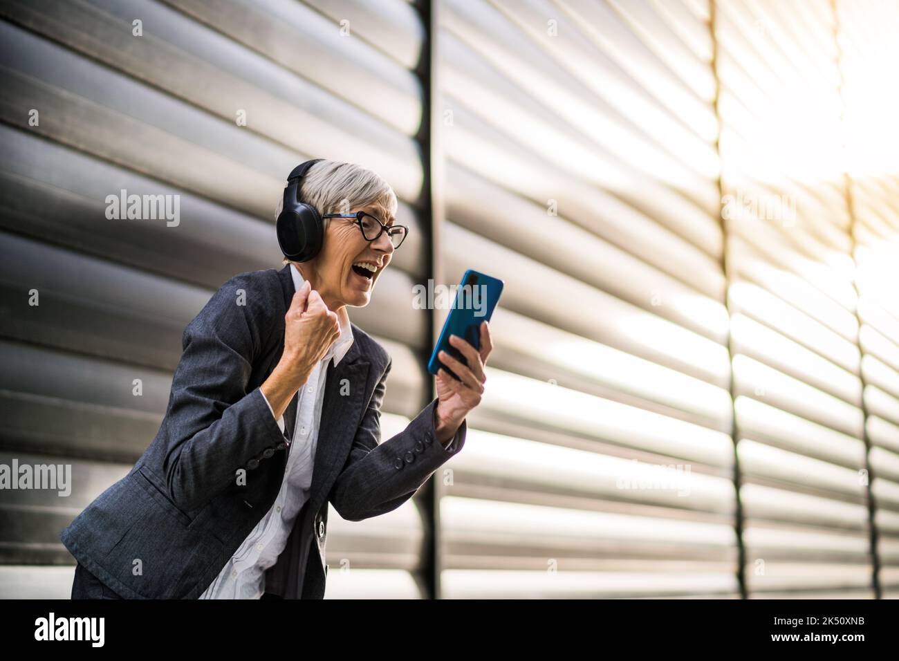 Portrait en plein air d'une femme d'affaires chevronnées qui utilise un smartphone en pause au travail. Banque D'Images