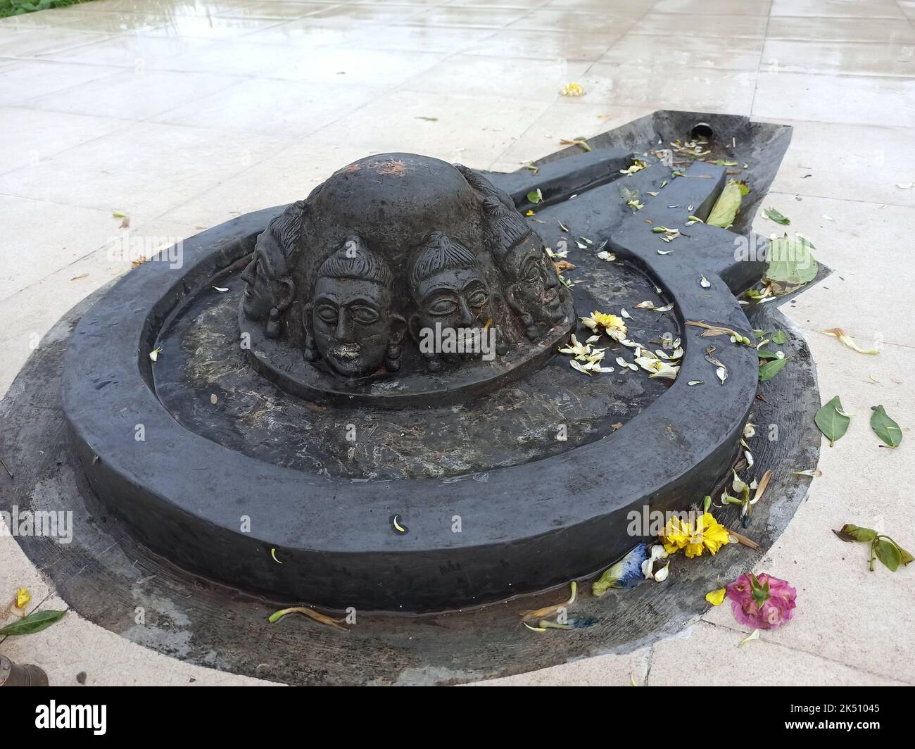 Un Shiva linga fait avec une pierre noire sur une surface plane avec un environnement fait de tuiles Banque D'Images