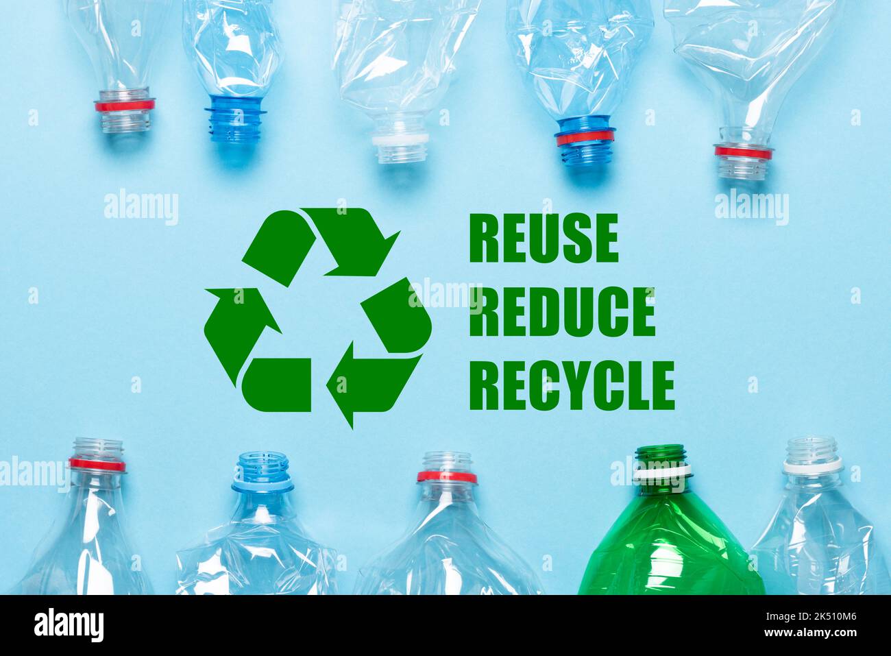 Symbole de recyclage et flacons en plastique sur fond bleu, vue de dessus Banque D'Images