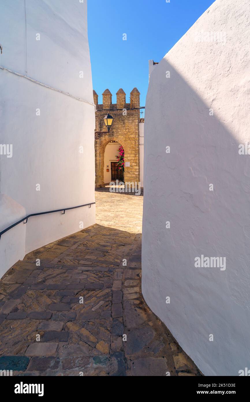 Vieilles maisons en pierre avec murs en plâtre blanc et allée étroite pavée de pierres menant à la construction de fort de maçonnerie en plein soleil Banque D'Images