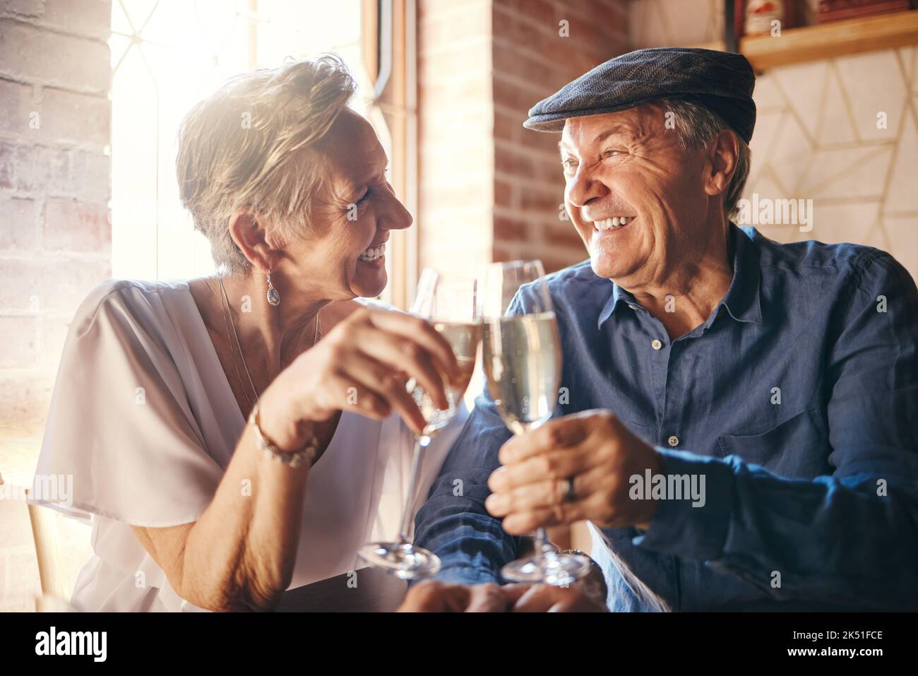 Couple de personnes âgées avec toast au champagne au restaurant pour anniversaire de mariage. Homme et femme senior avec boisson alcoolisée célébrant l'amour, la famille et Banque D'Images