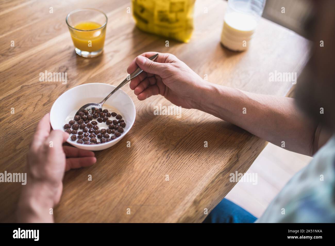 Homme caucasien mature assis à la table et prenant le petit déjeuner Banque D'Images