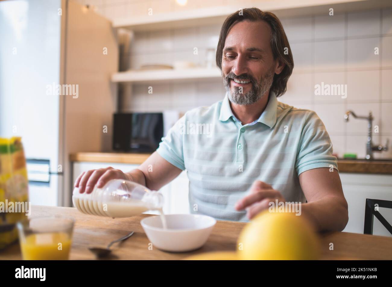 Homme seul prenant le petit déjeuner dans la cuisine à la maison Banque D'Images