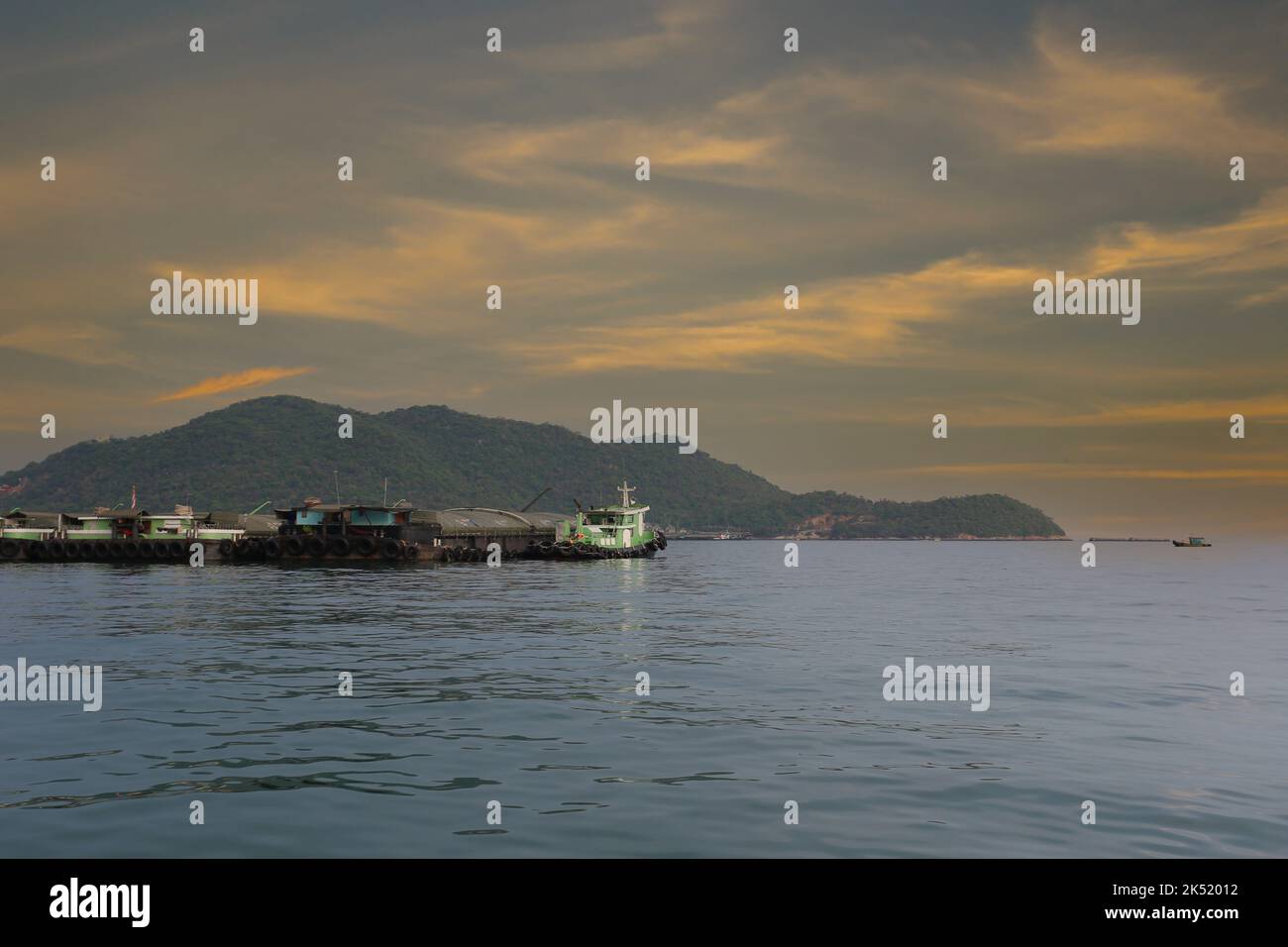 Remorqueurs et cargos amarrés dans la baie de Koh Sichang, province de Chonburi en Thaïlande, le ciel est le coucher du soleil. Banque D'Images