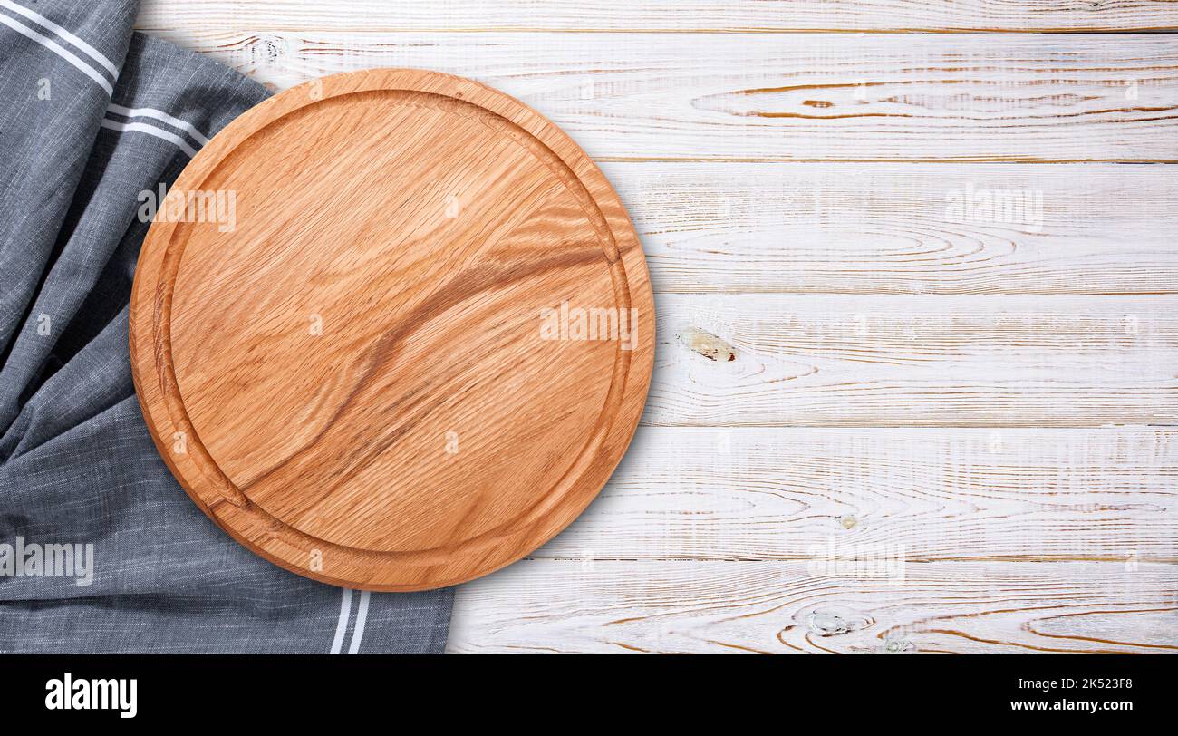 Plateau à pizza avec une serviette sur une table en bois blanc. Maquette de la vue de dessus Banque D'Images