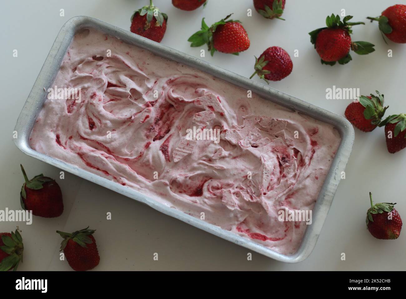 Glace à la fraise maison sortie du congélateur dans un moule à pain. Crème glacée à trois ingrédients faite de fraises fraîches, de crème épaisse ou de crème fouettée Banque D'Images
