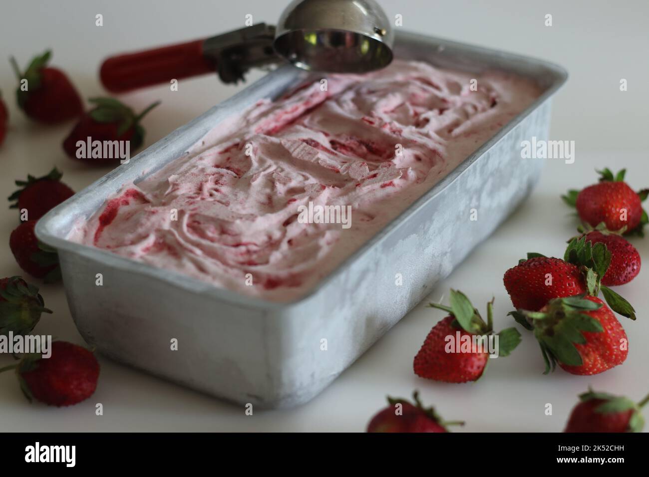 Glace à la fraise maison sortie du congélateur dans un moule à pain. Crème glacée à trois ingrédients faite de fraises fraîches, de crème épaisse ou de crème fouettée Banque D'Images